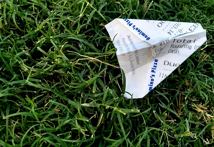 Avioncito de papel sobre el césped